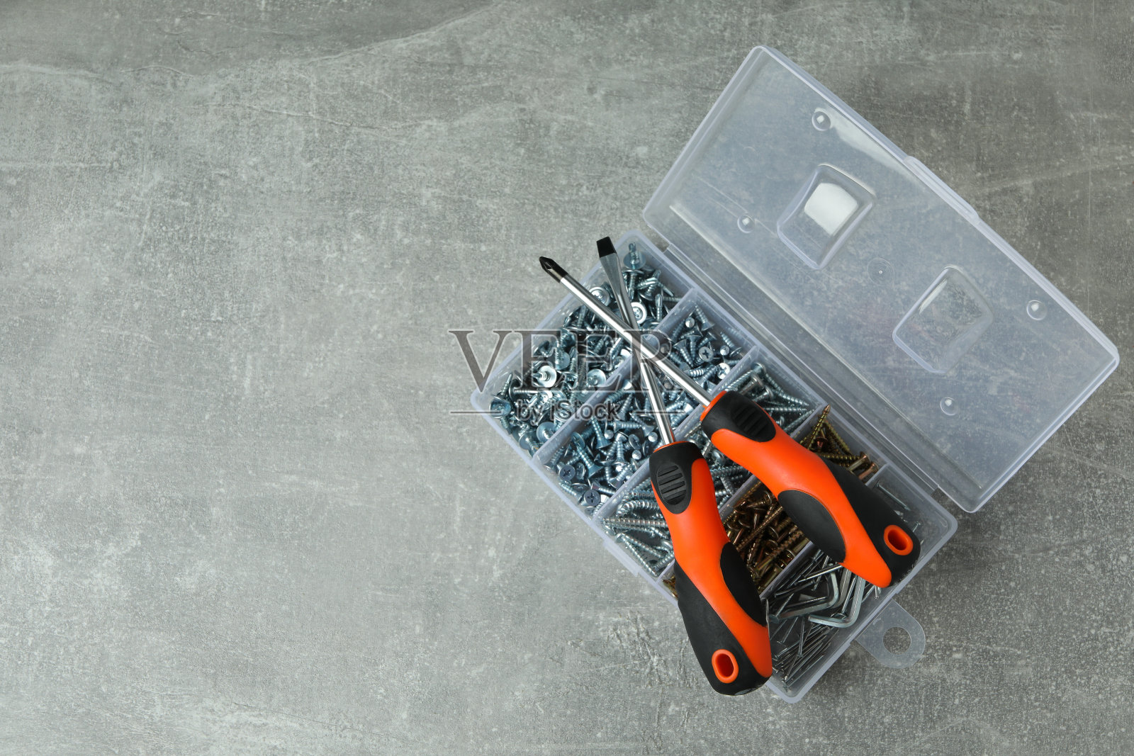 灰色纹理背景上带有螺丝和螺丝刀的盒子照片摄影图片