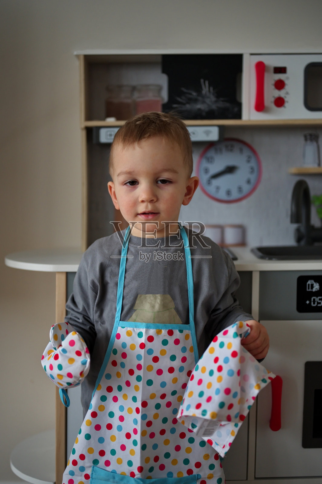 小孩拿着玩具厨房照片摄影图片