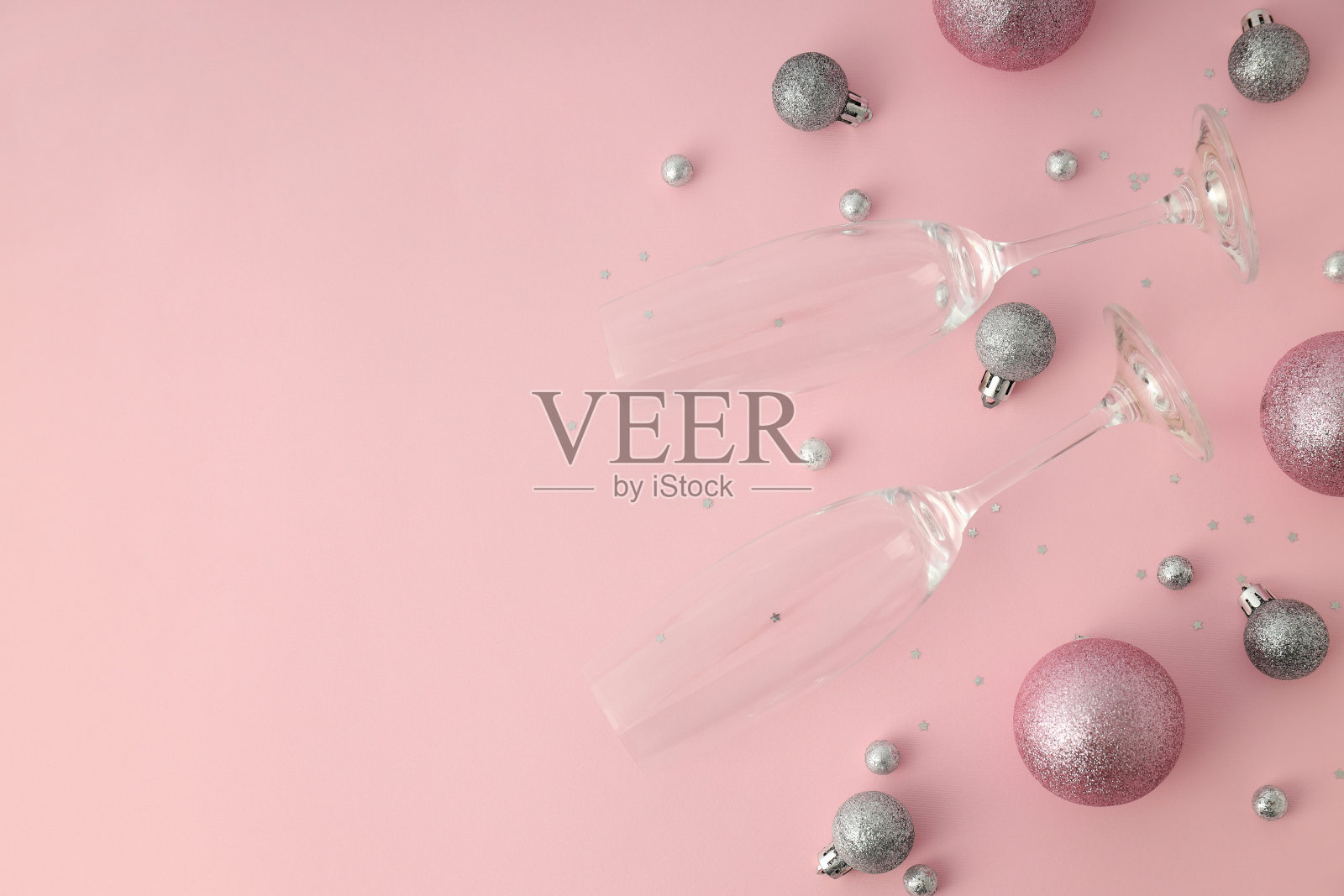 粉色背景上的香槟酒杯和小玩意照片摄影图片