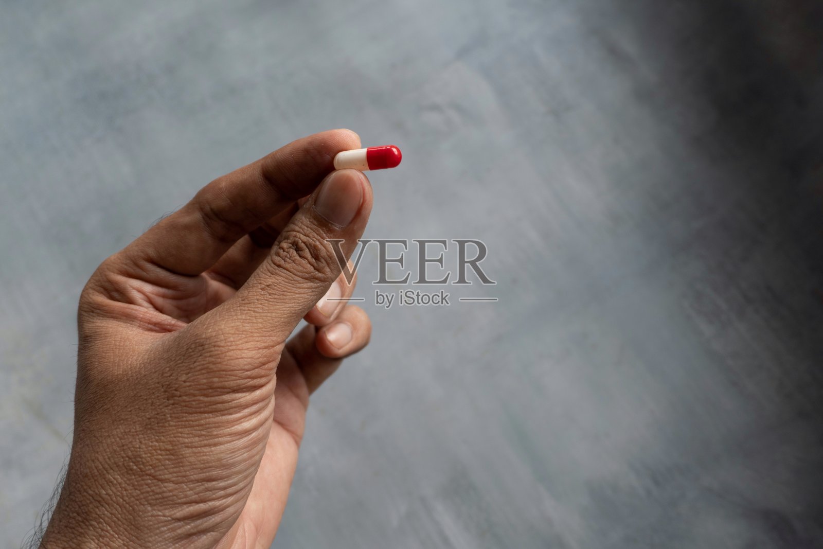 手握白色和红色药丸与复制空间。照片摄影图片