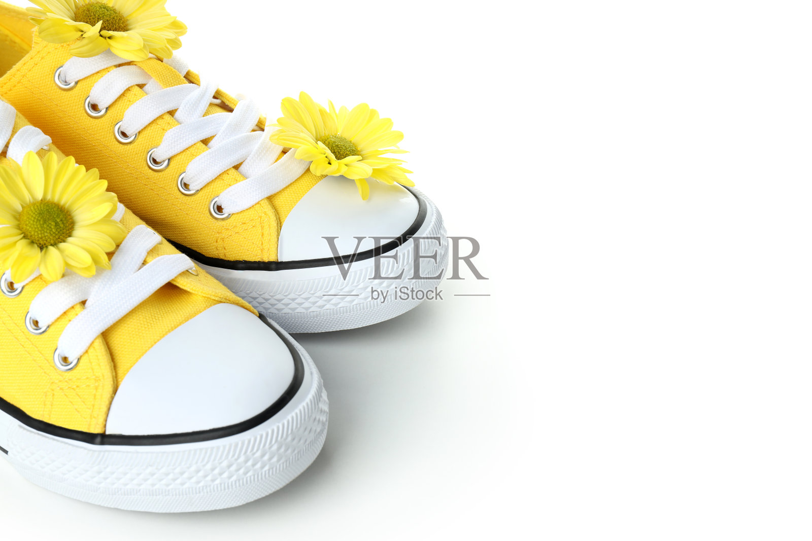 白色背景上有花的黄色运动鞋照片摄影图片