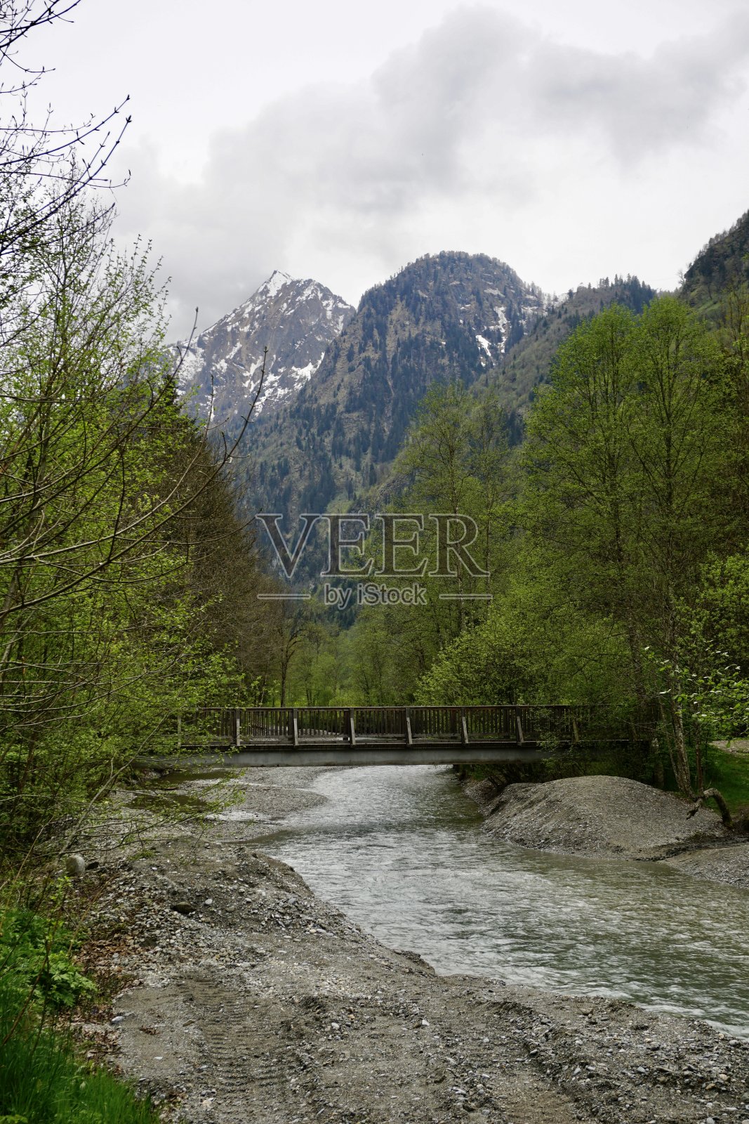 山里的一条小溪。山涧有桥。山间小溪上的桥。阿尔卑斯山中的一条小河。照片摄影图片