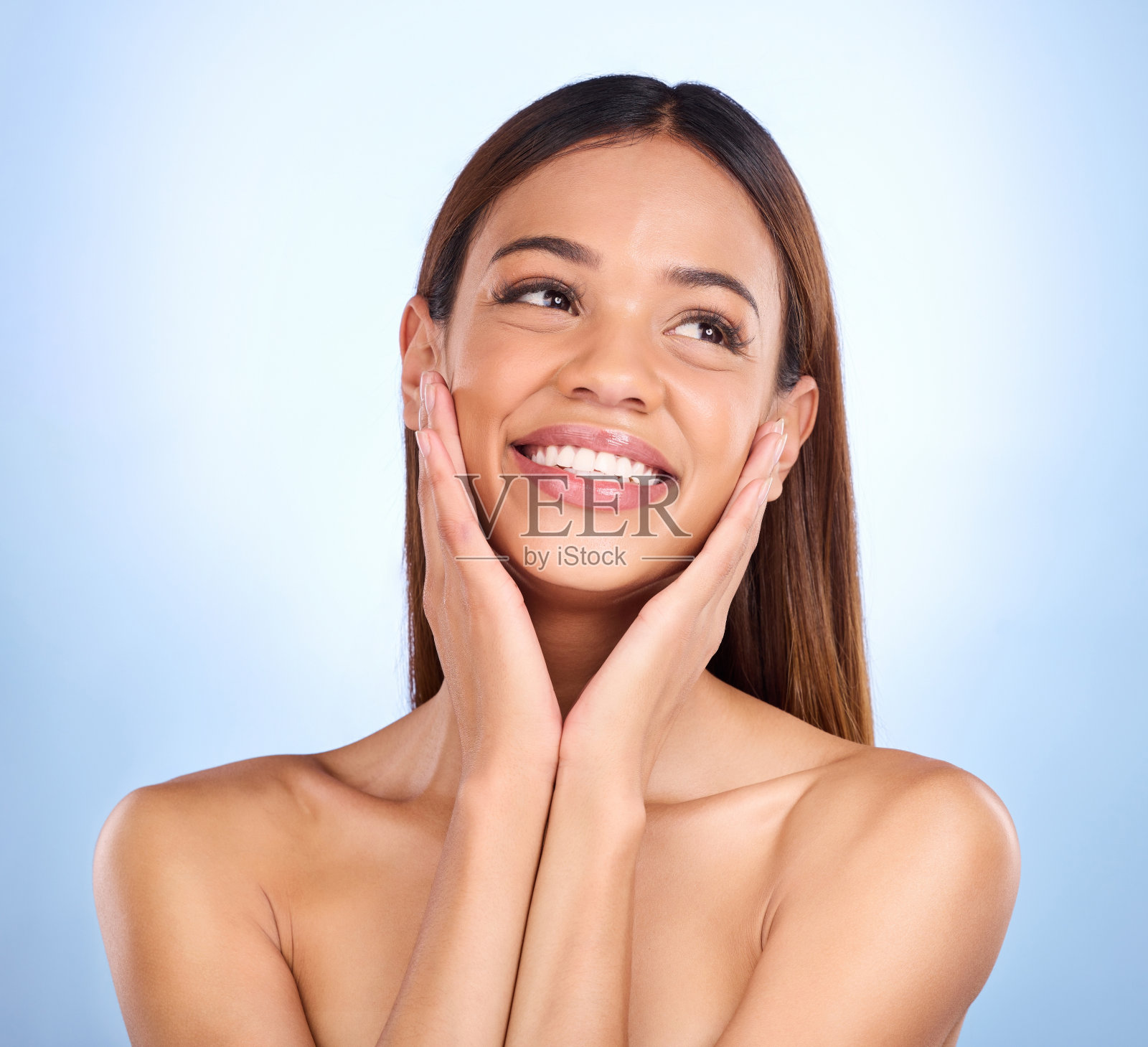 女人,在美丽的皮肤护理化妆品或自爱和护理蓝色工作室背景下的脸和微笑。快乐的女性,化妆触摸完美的皮肤,满意的面部或水疗治疗照片摄影图片