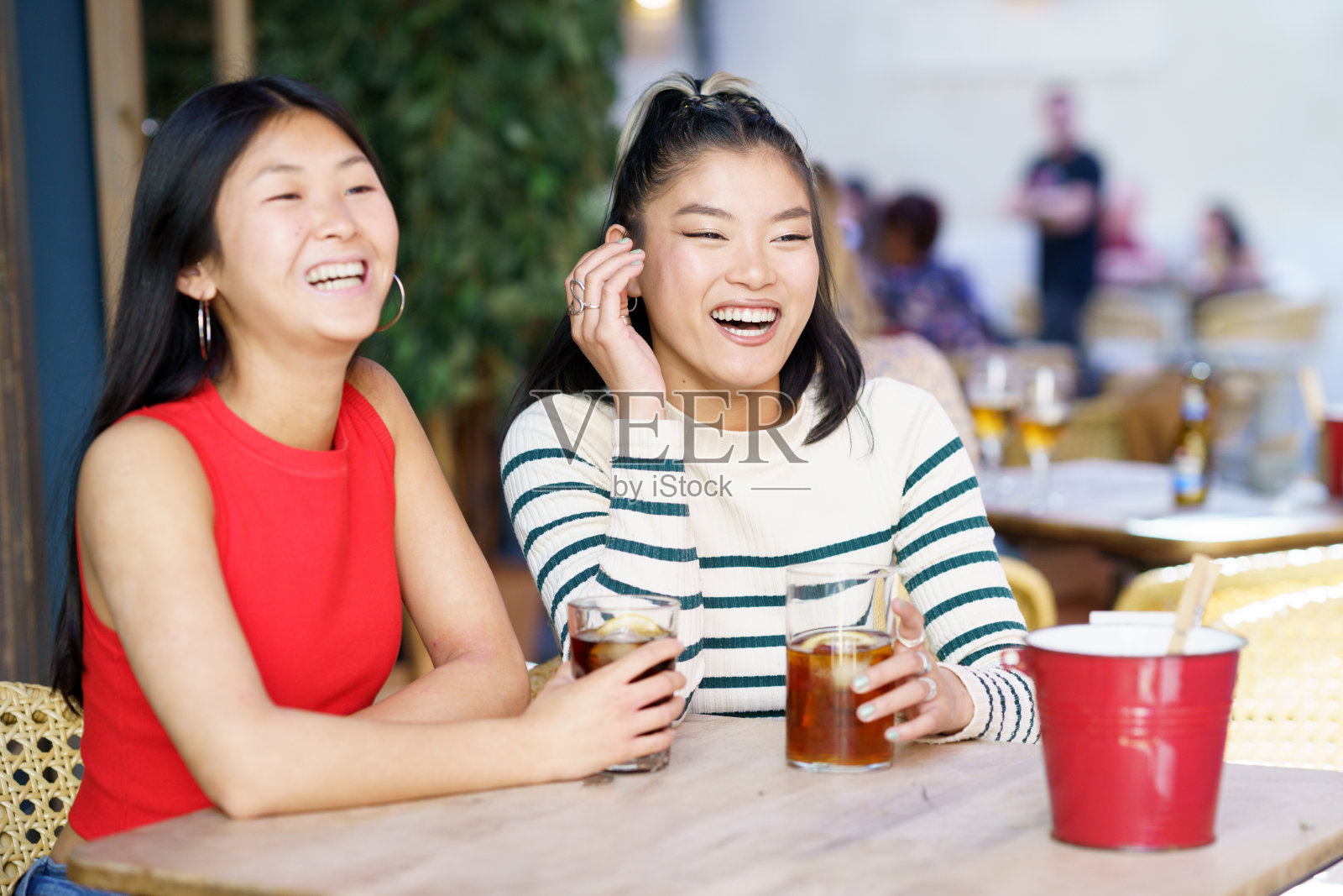 快乐的亚洲女人在咖啡馆里喝着饮料休息照片摄影图片