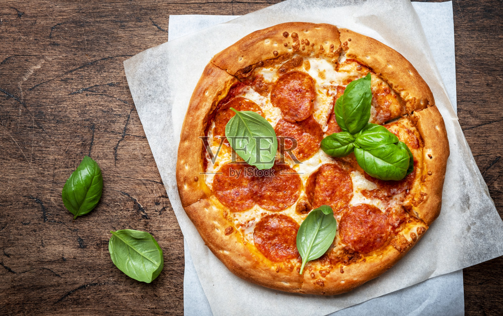 辣香肠披萨配辣腊肠,马苏里拉奶酪,番茄酱和绿色罗勒,白色桌面背景,俯视图照片摄影图片