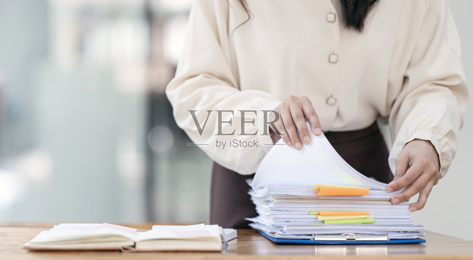 女商人在成堆的纸质文件中工作,用于搜索和检查未完成的文件照片摄影图片