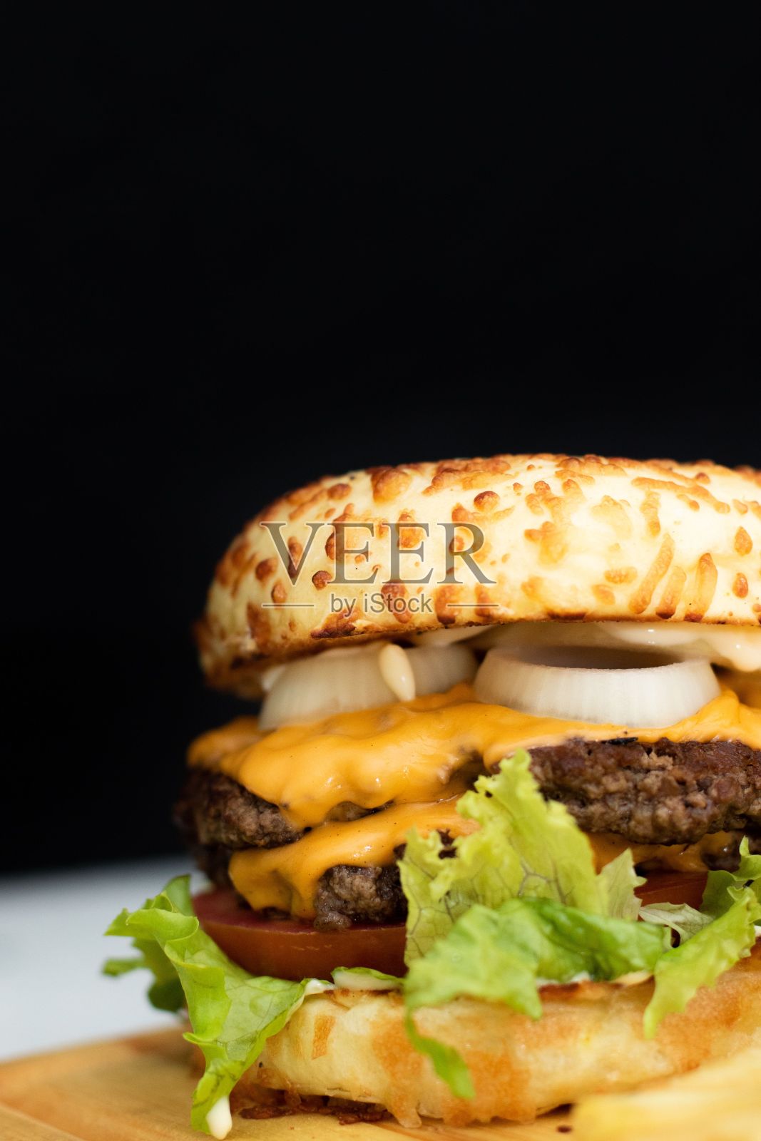 美味的芝士汉堡陈列在砧板上。照片摄影图片