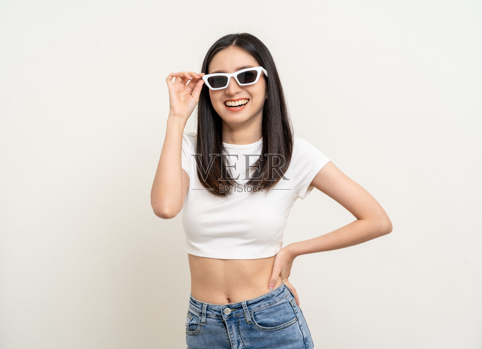 有吸引力的美丽的亚洲女人站立和摆姿势。性感的女性微笑着快乐的时尚,在孤立的背景上戴着太阳镜。照片摄影图片