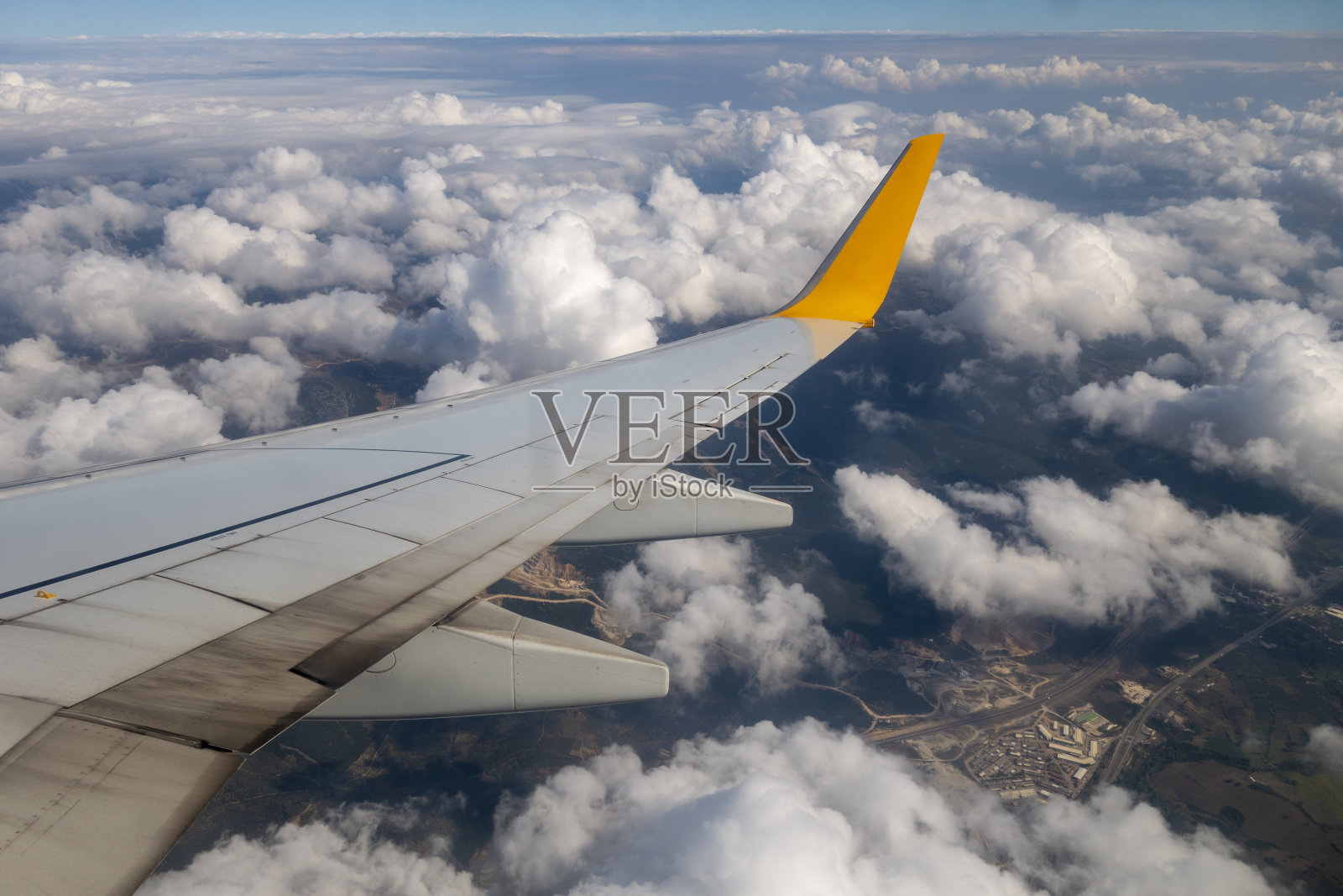 飞机的机翼在天空的云层上飞行照片摄影图片