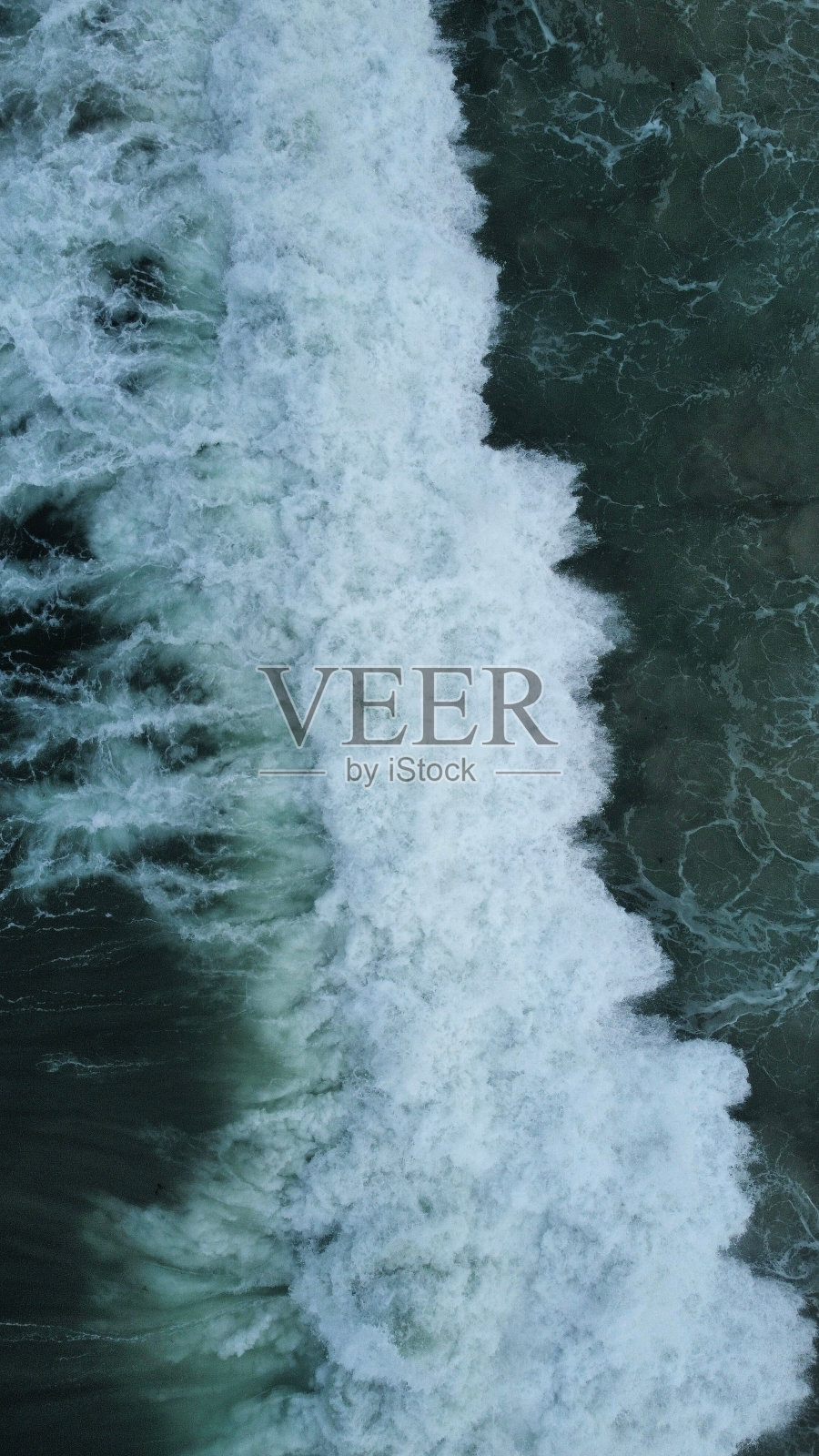 航拍波涛冲击海岸线的画面。照片摄影图片