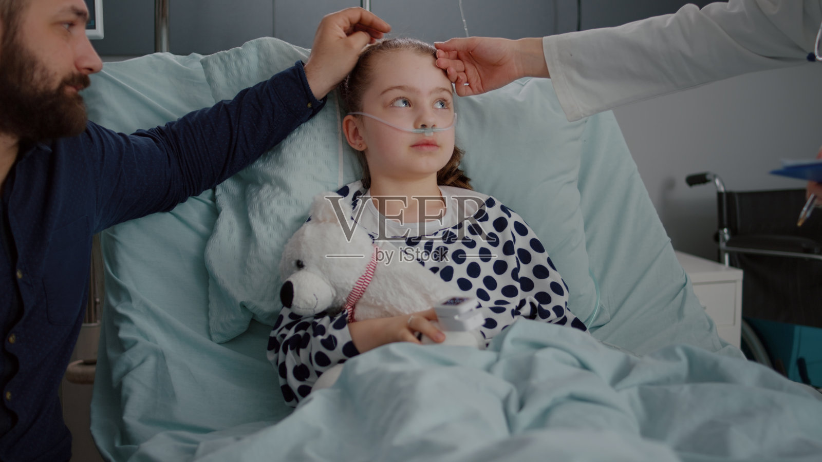 忧心忡忡的父亲坐在住院检查生病的女儿身边照片摄影图片