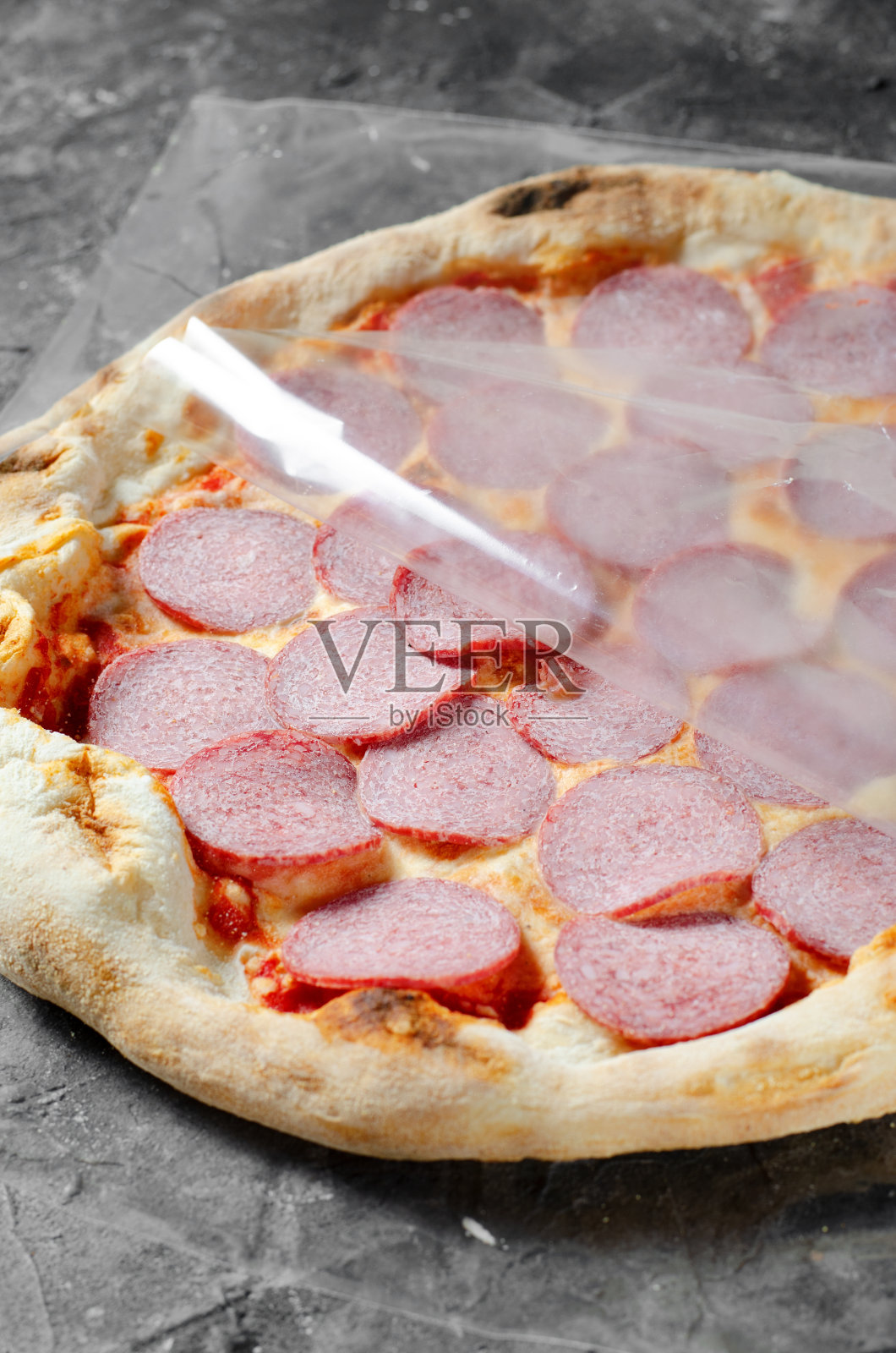 冷冻香肠披萨在黑暗的背景,石头烤披萨准备烘烤照片摄影图片