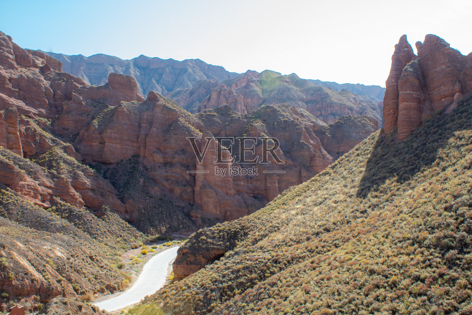 甘肃张掖冰沟丹霞峡谷地貌鸟瞰图。地质公园内尖尖的山峰。阳光明媚的日子里山谷里的路。照片摄影图片