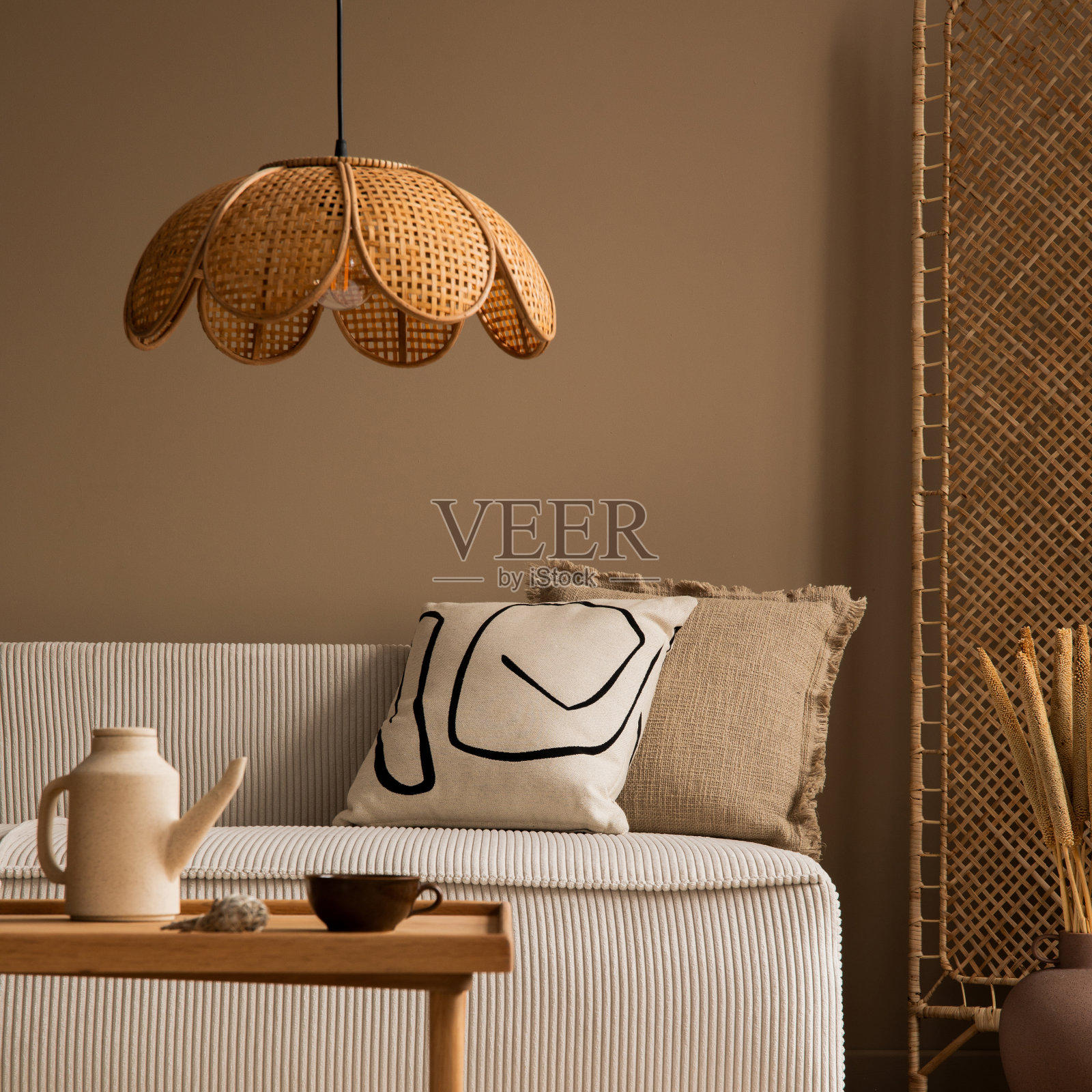 客厅内部以模块化沙发、隔墙、木茶几、圆枕、干花花瓶、藤灯及个人饰品的美学构成。家居装饰。模板照片摄影图片