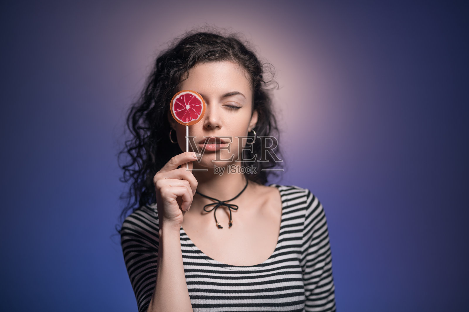 工作室拍摄的黑发女人拿着美味的糖果照片摄影图片