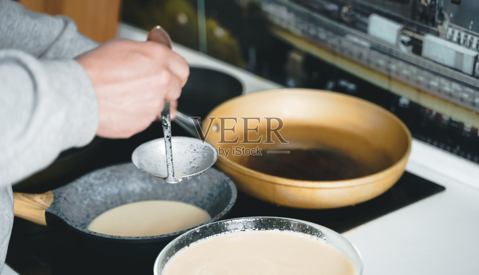 俄罗斯莫斯科,2021年3月14日,做许多大而美味的煎饼。俄罗斯传统的民族节日冬至节(Maslenitsa),节日周,忏悔节。伙计,库克神父。家庭度假照片摄影图片