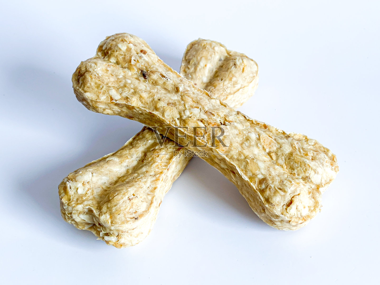 狗啃的骨头粘在白色的背景上照片摄影图片