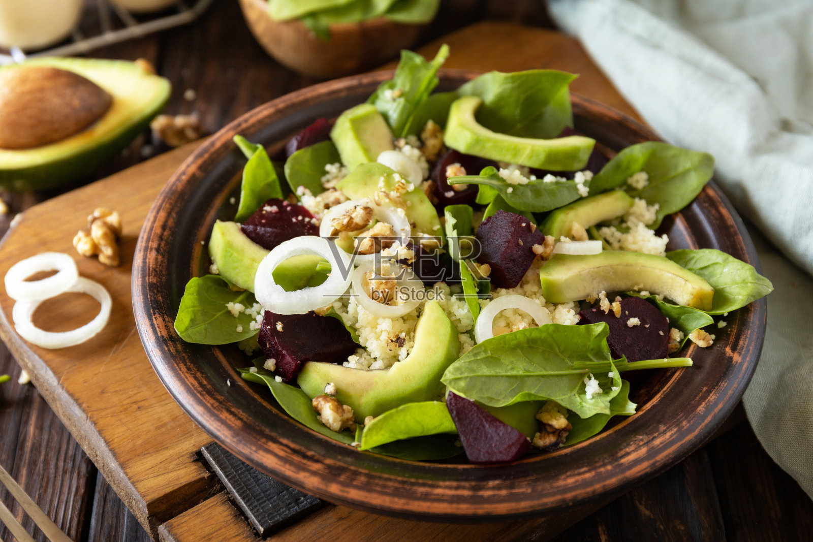 素食,低热量节食餐。在一张质朴的木桌上,蒸粗麦粉配上鳄梨、甜菜、青豆和菠菜。照片摄影图片