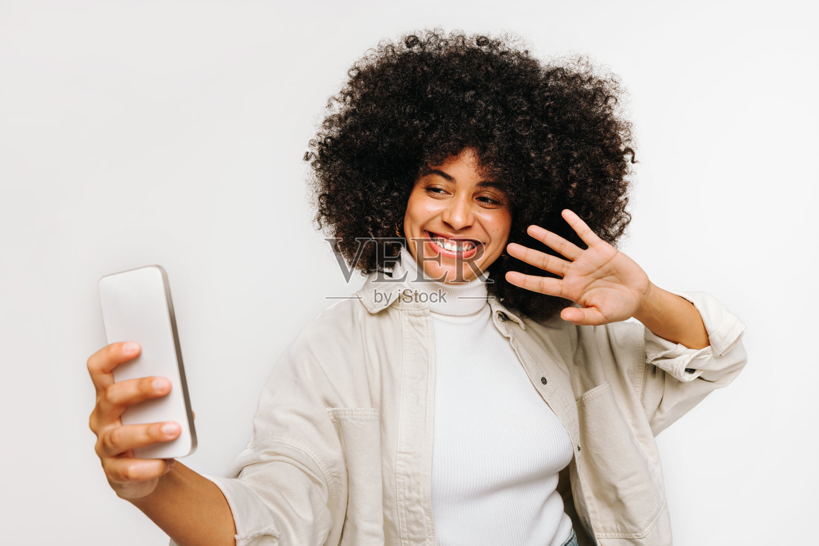 卷发美女正在用智能手机进行视频通话照片摄影图片