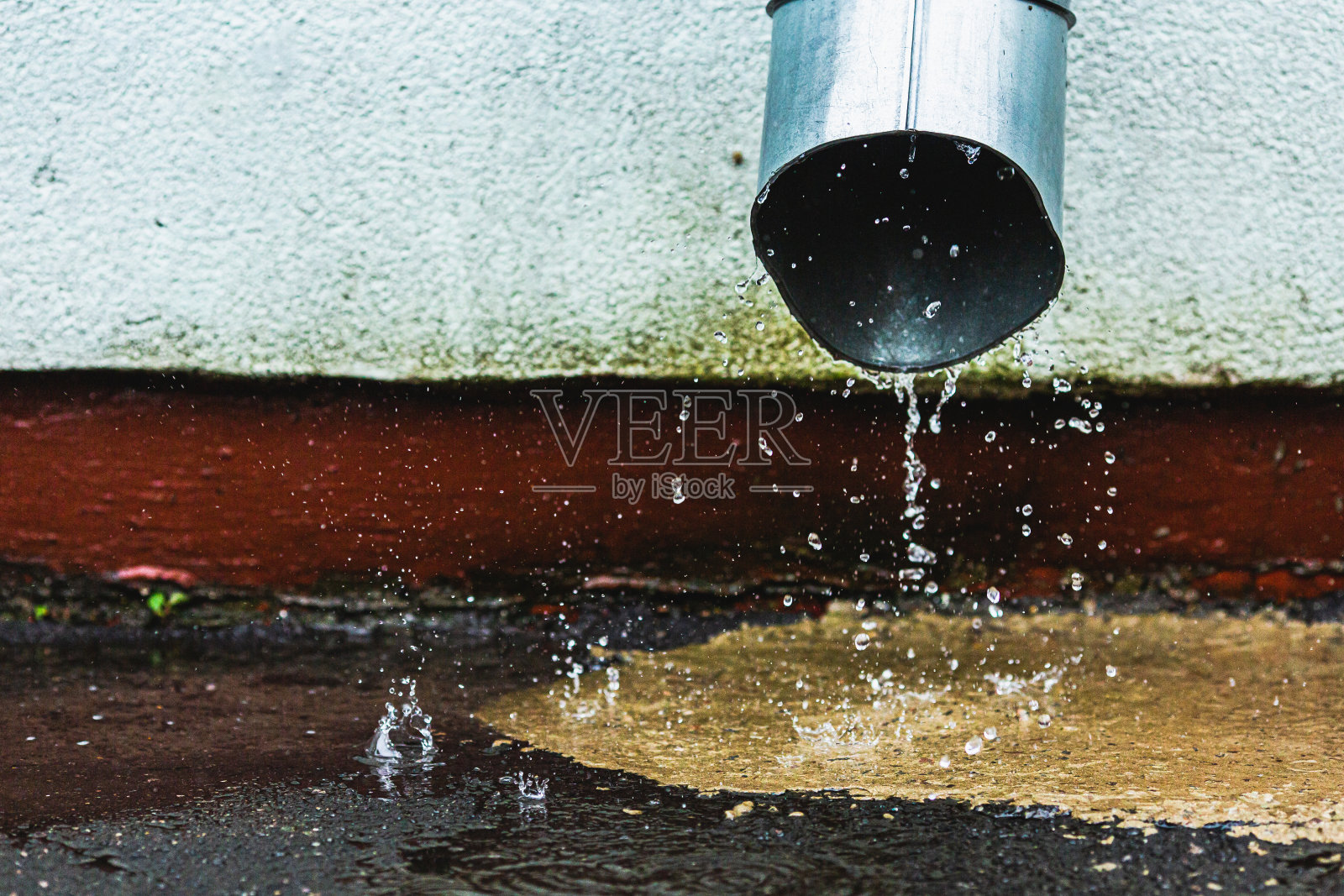 浪费了雨水。水管。洪水。暴雨。多雨的天气。水滴。雨滴。排水照片摄影图片