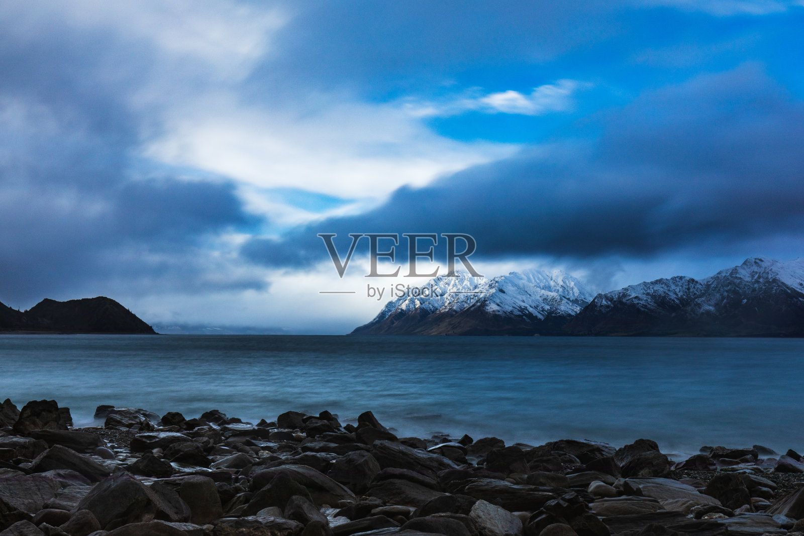 长时间曝光的湖泊与戏剧性的景观雪山为背景照片摄影图片