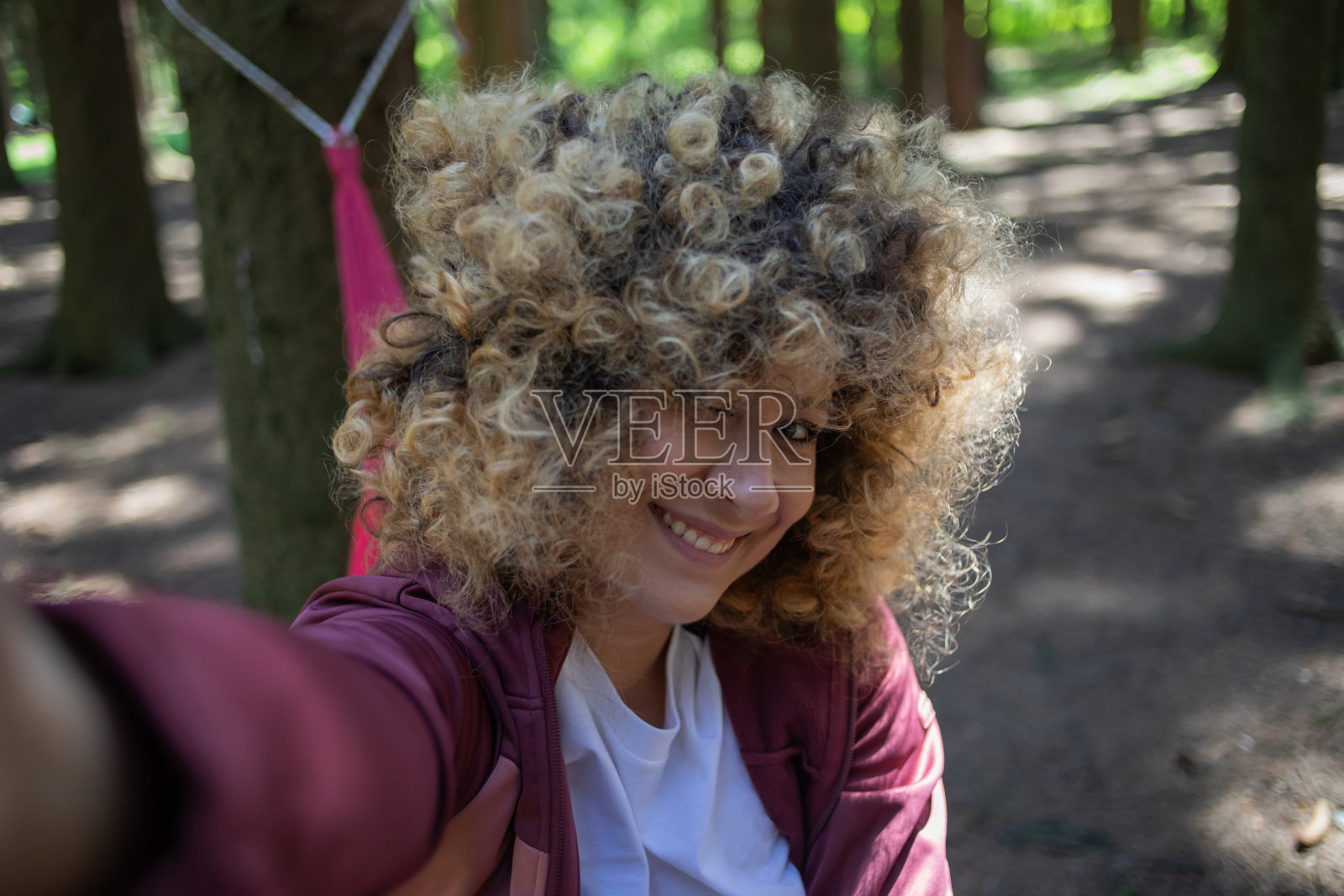 美丽的年轻女子的特写肖像与自然卷曲的头发。照片摄影图片