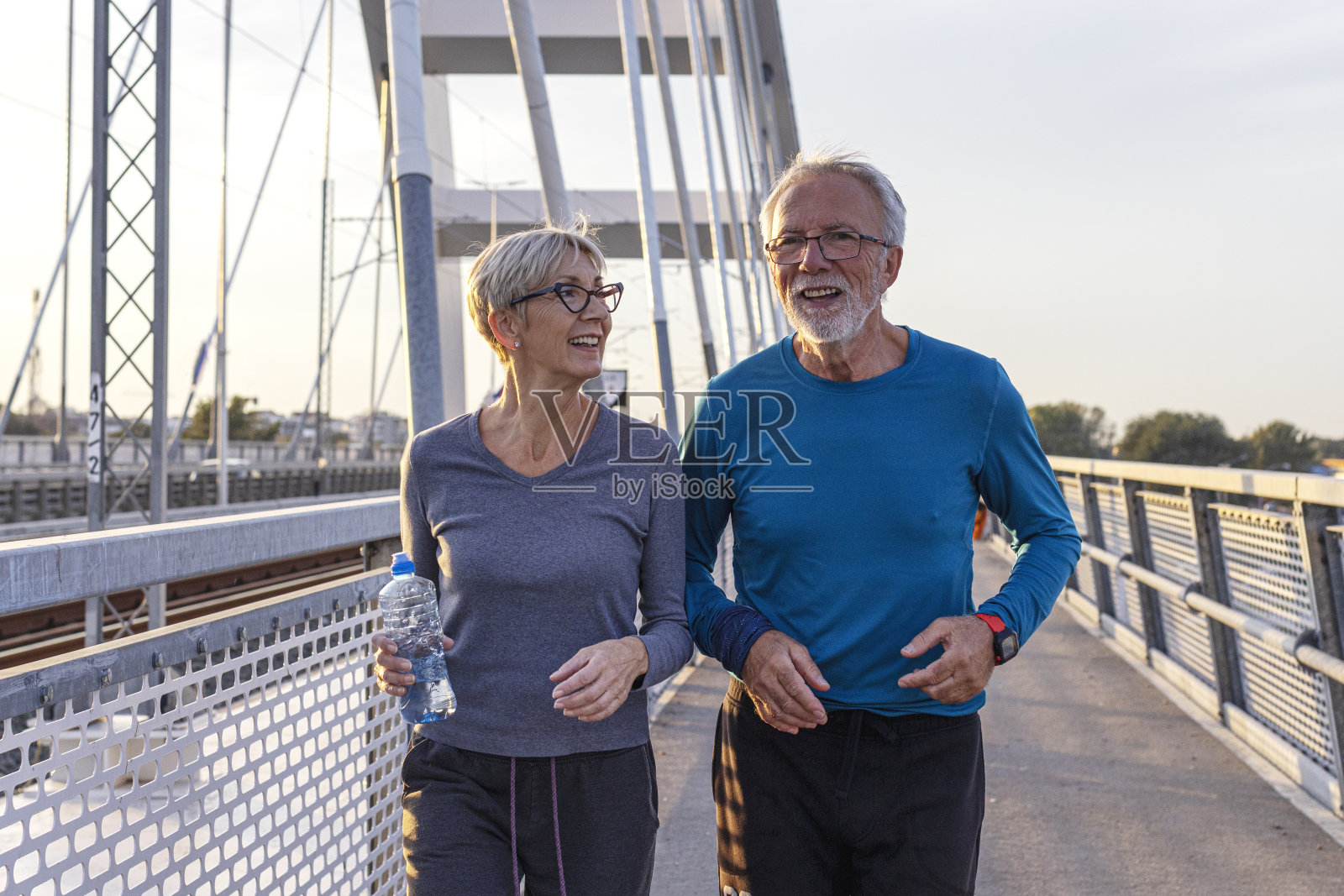 老年人在一天结束时穿着运动服在桥上慢跑照片摄影图片