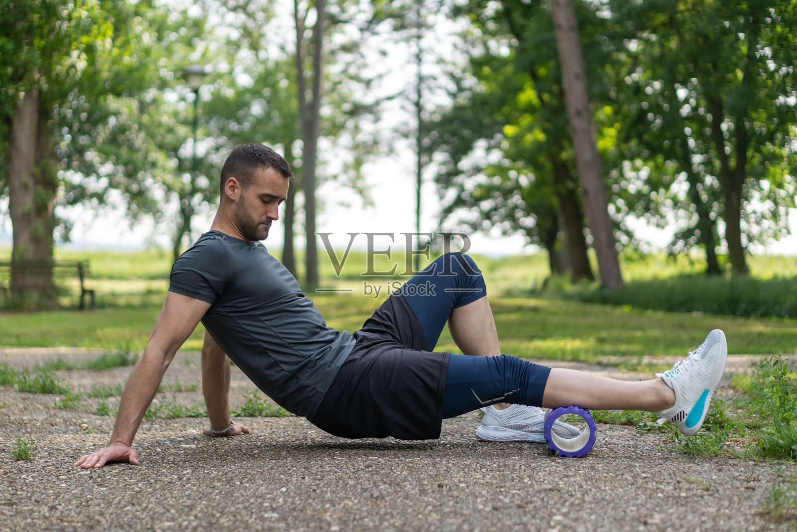 年轻人在公园里用运动器材训练。照片摄影图片