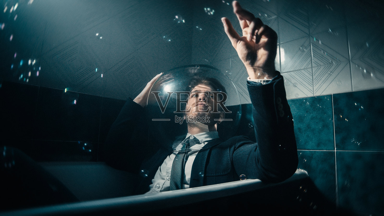 打着领带在浴缸里泡肥皂的男人照片摄影图片