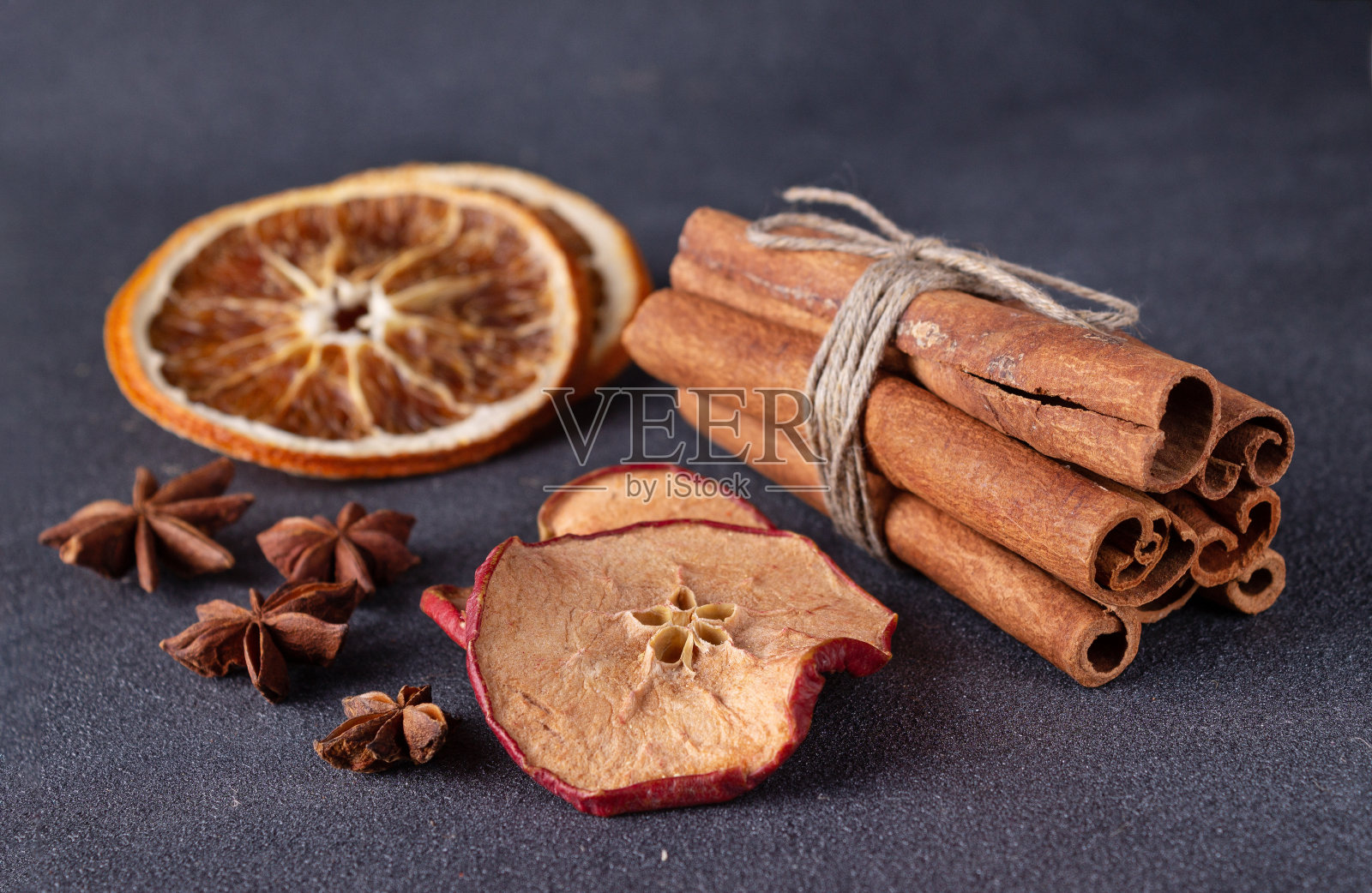 肉桂棒,茴香,干橘子和苹果在黑暗的背景,特写照片摄影图片
