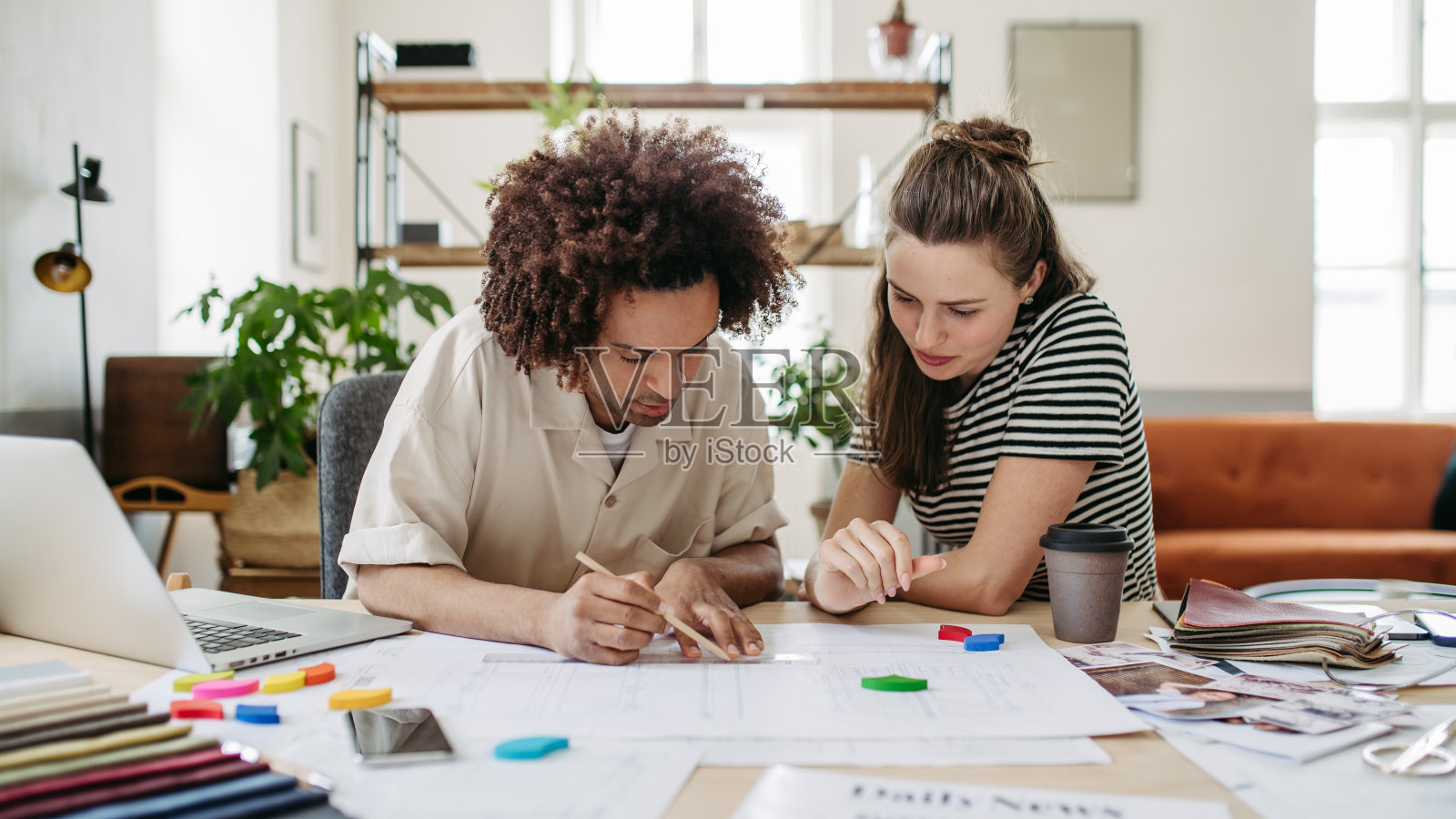 年轻的同事在摄影工作室一起工作。照片摄影图片