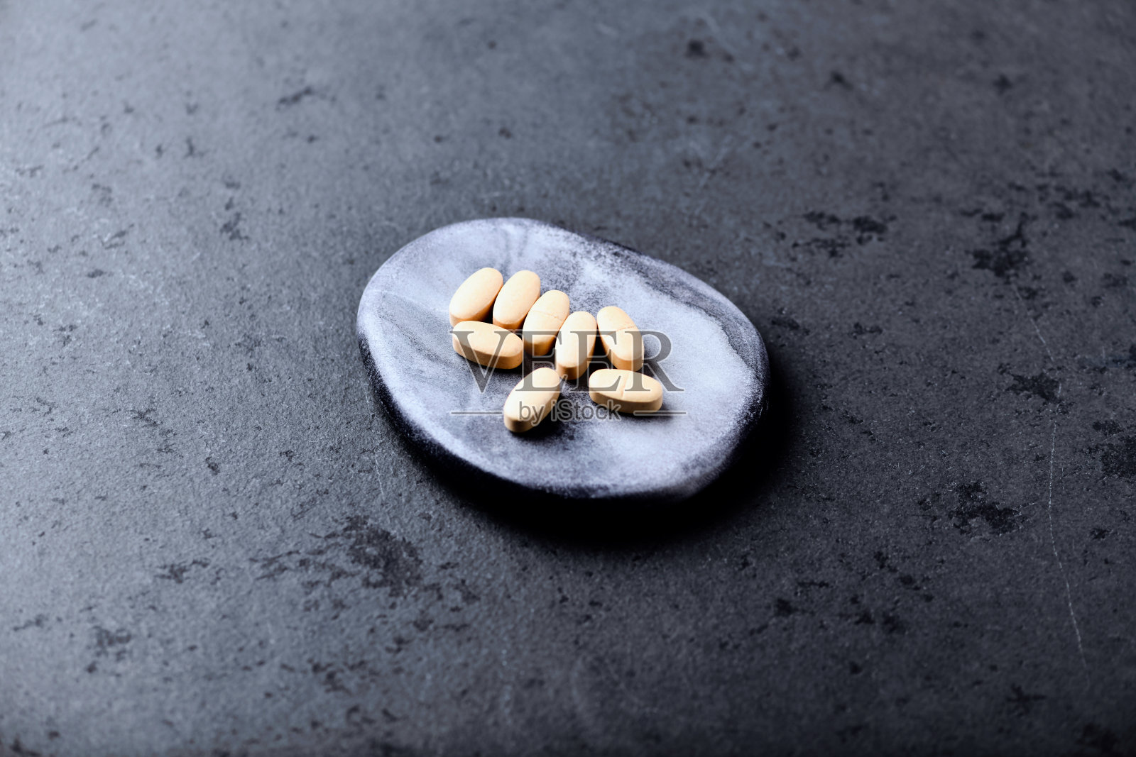 暗石底色维生素C片。软的焦点。关闭了。照片摄影图片