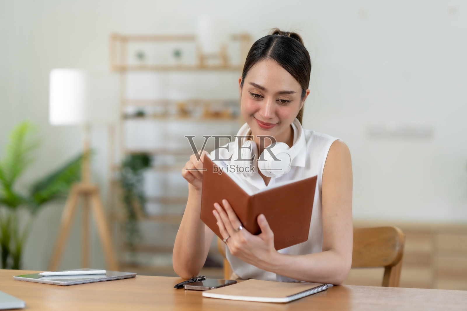 有魅力和美丽的亚洲女性在家里读书和工作,他们的闲暇和享受阅读的假期。照片摄影图片