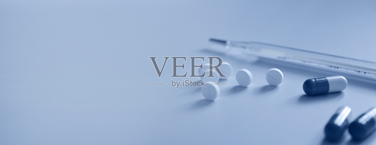 背景为医疗网站或文章,药片和水银温度计在蓝色背景,药品,医疗保健,横幅照片摄影图片