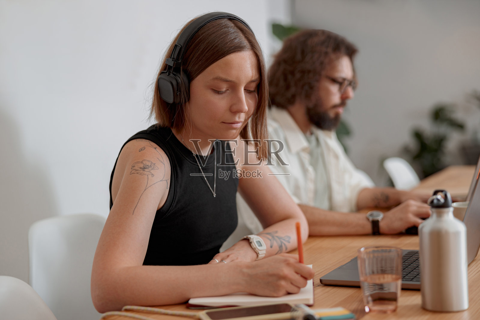 女自由职业者在舒适的同事背景下工作时做笔记照片摄影图片