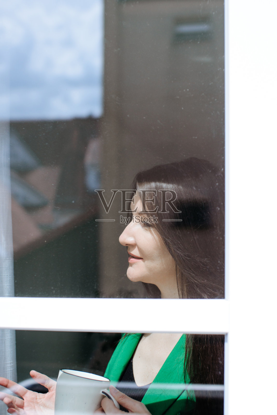 透过窗户拍的办公室里一个女孩的肖像照片摄影图片