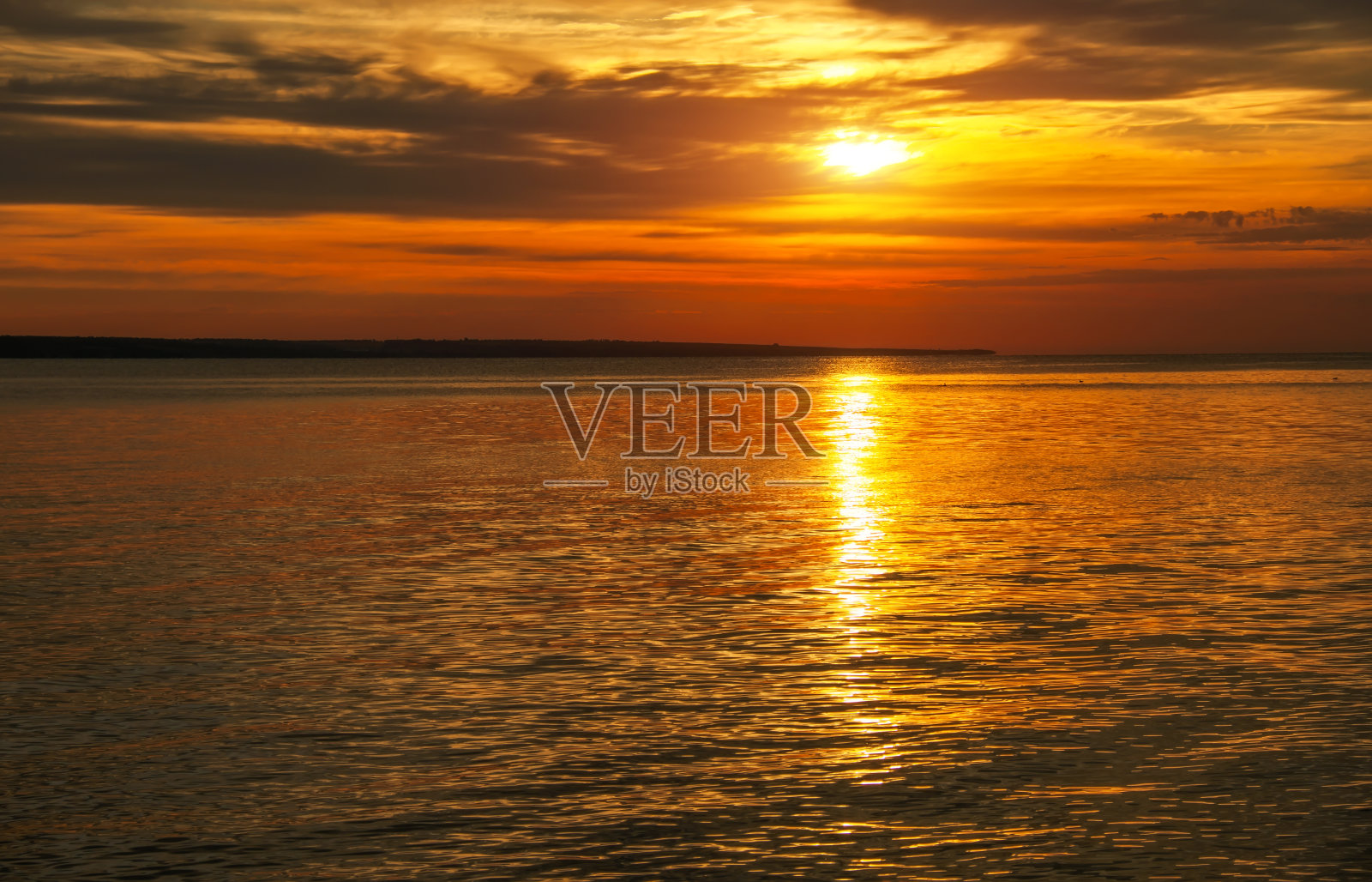 天空中有云彩的日落。海上令人惊叹的日落照片摄影图片