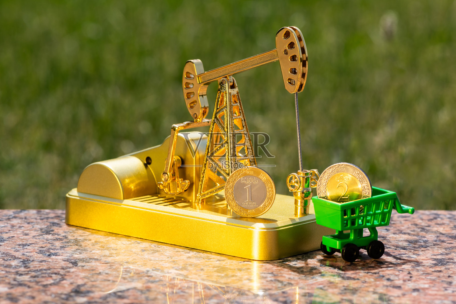 沙特阿拉伯王国1里亚尔和2里亚尔硬币及金色石油泵模型照片摄影图片