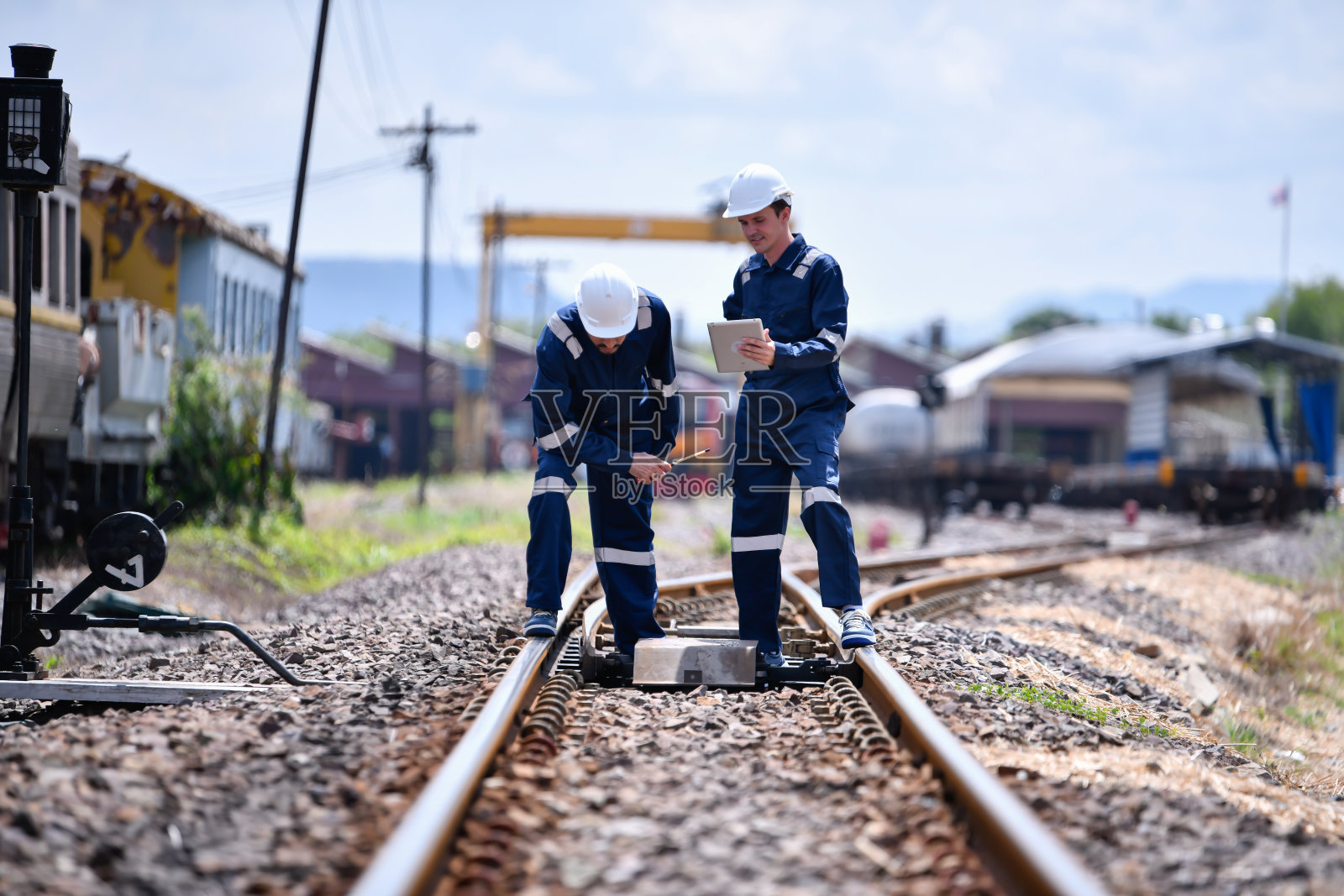 铁路检查工程师,铁路施工过程,列车测试和车站无线电通信检查铁路工作。工程师在工作中穿着安全制服和安全帽。照片摄影图片