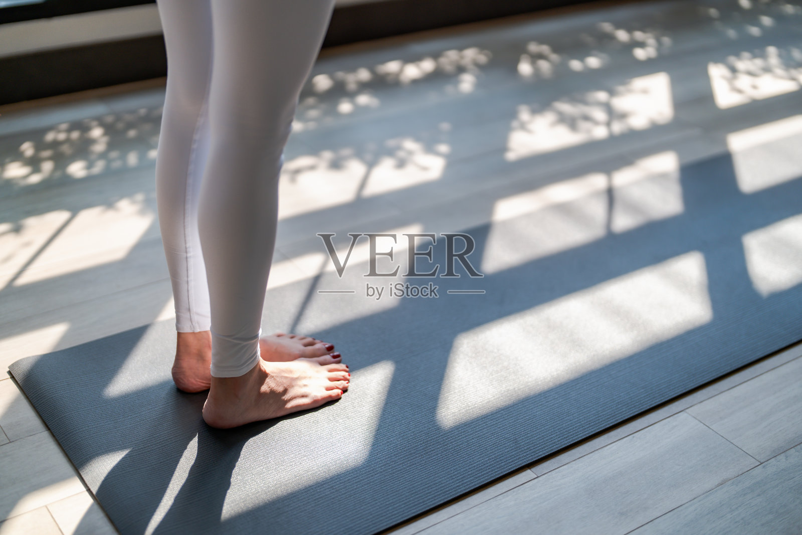 健身训练女子站在瑜伽课上。站在健身房的瑜伽垫上。照片摄影图片