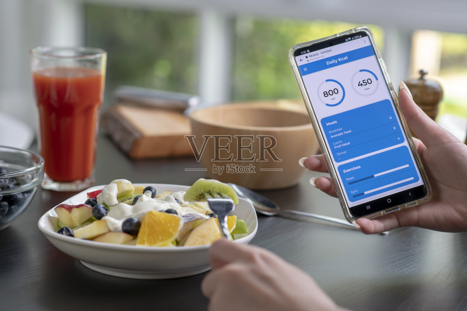 女人在吃饭的时候在手机上查看卡路里和营养照片摄影图片