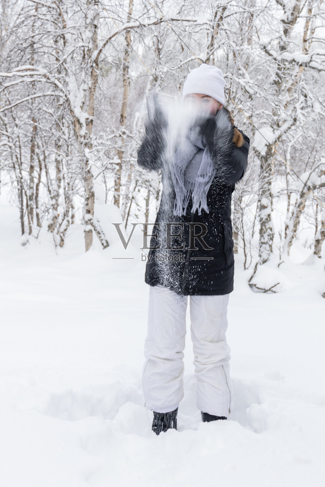 年轻女孩把雪抛向空中照片摄影图片