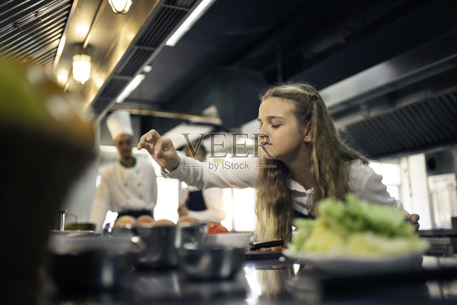 厨师学徒正在烹饪学校的厨房里做饭。照片摄影图片