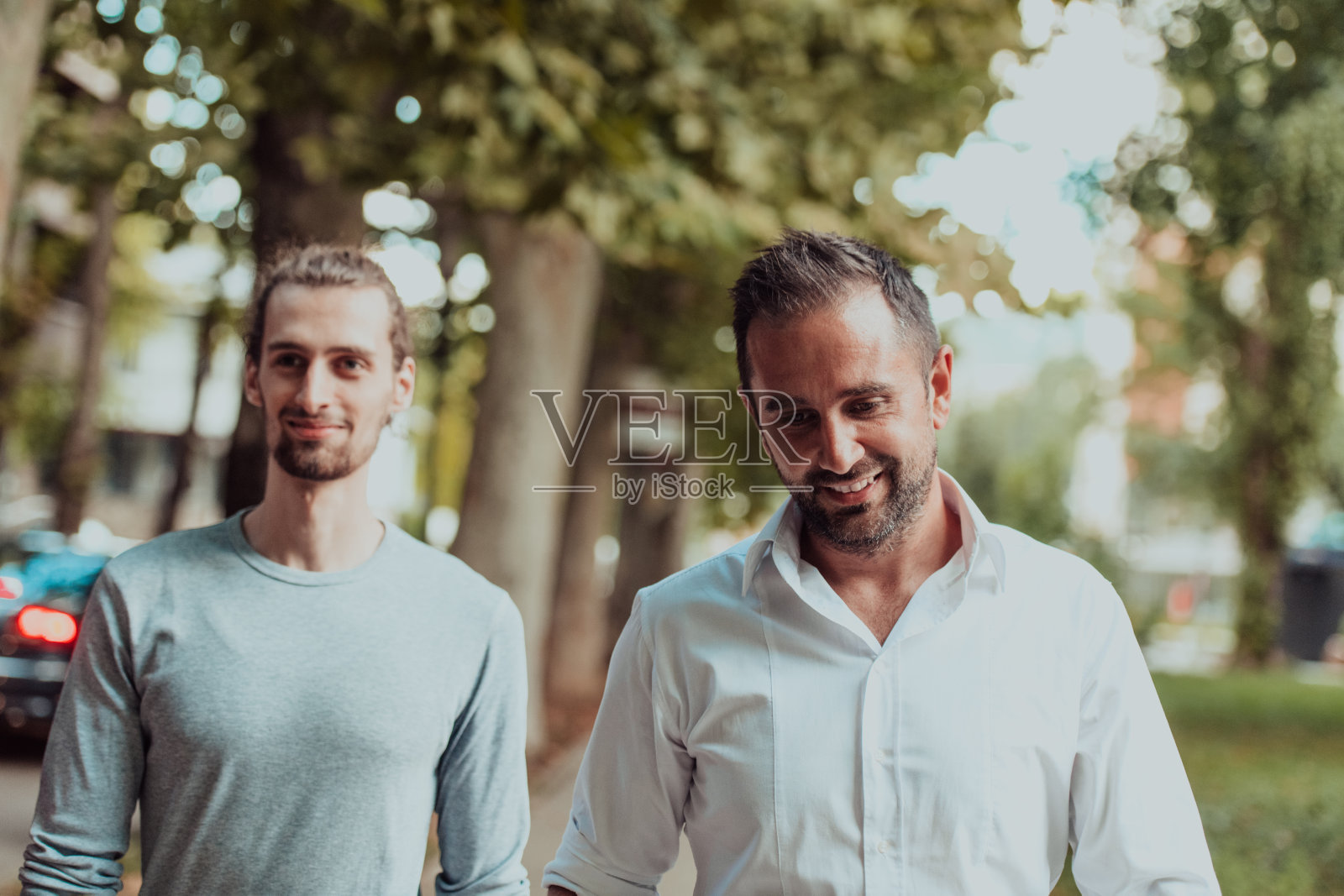 忙碌了一天后,一群不同的同事在现代自然的城市环境中悠闲地散步照片摄影图片