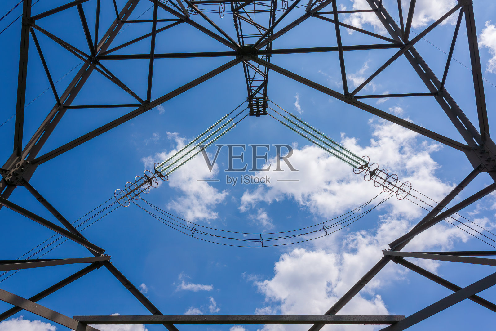 低角度看高压塔,背景是多云的天空照片摄影图片