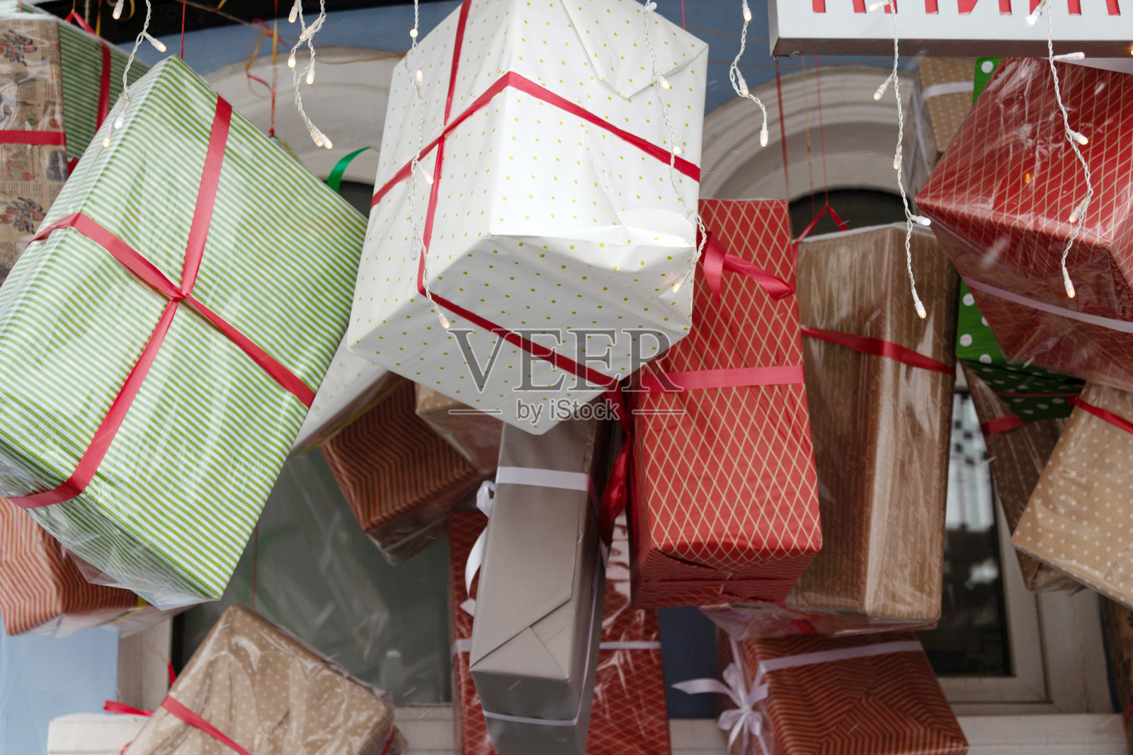 礼品盒和装有灯泡的花环装饰着商店的入口照片摄影图片