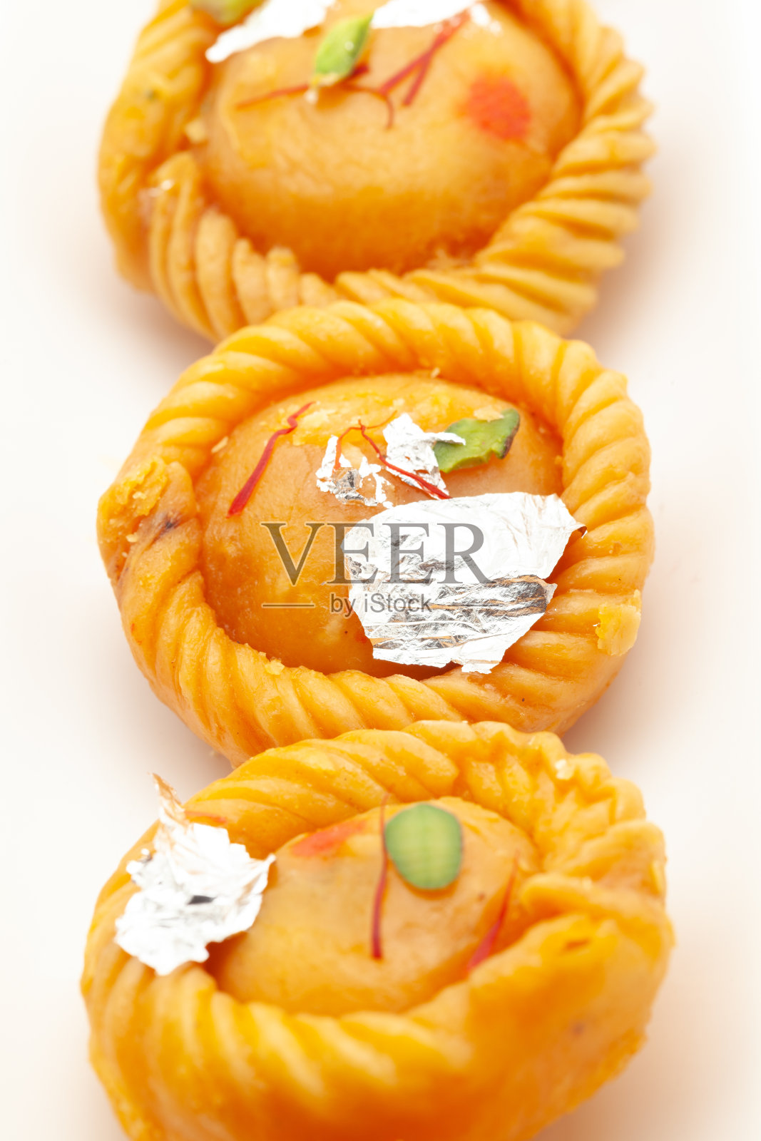 印度传统甜点“Chandrakala”的特写,里面装满了干果。照片摄影图片