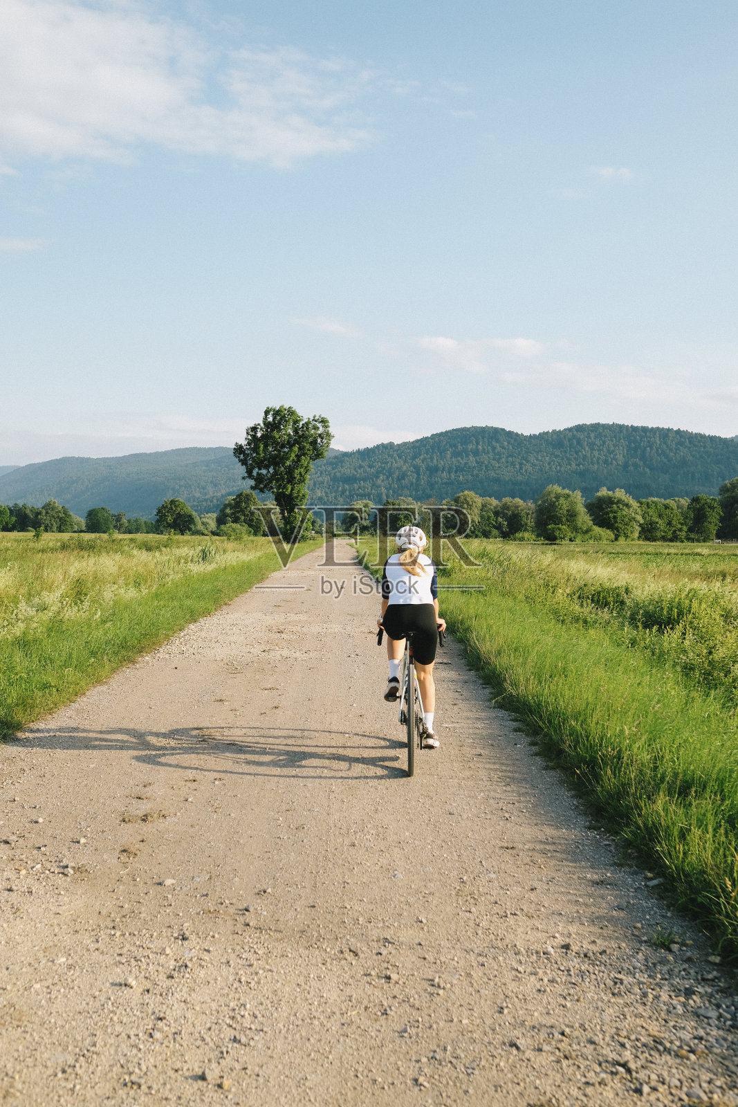 年轻女子在乡间小路上骑着砂石自行车照片摄影图片