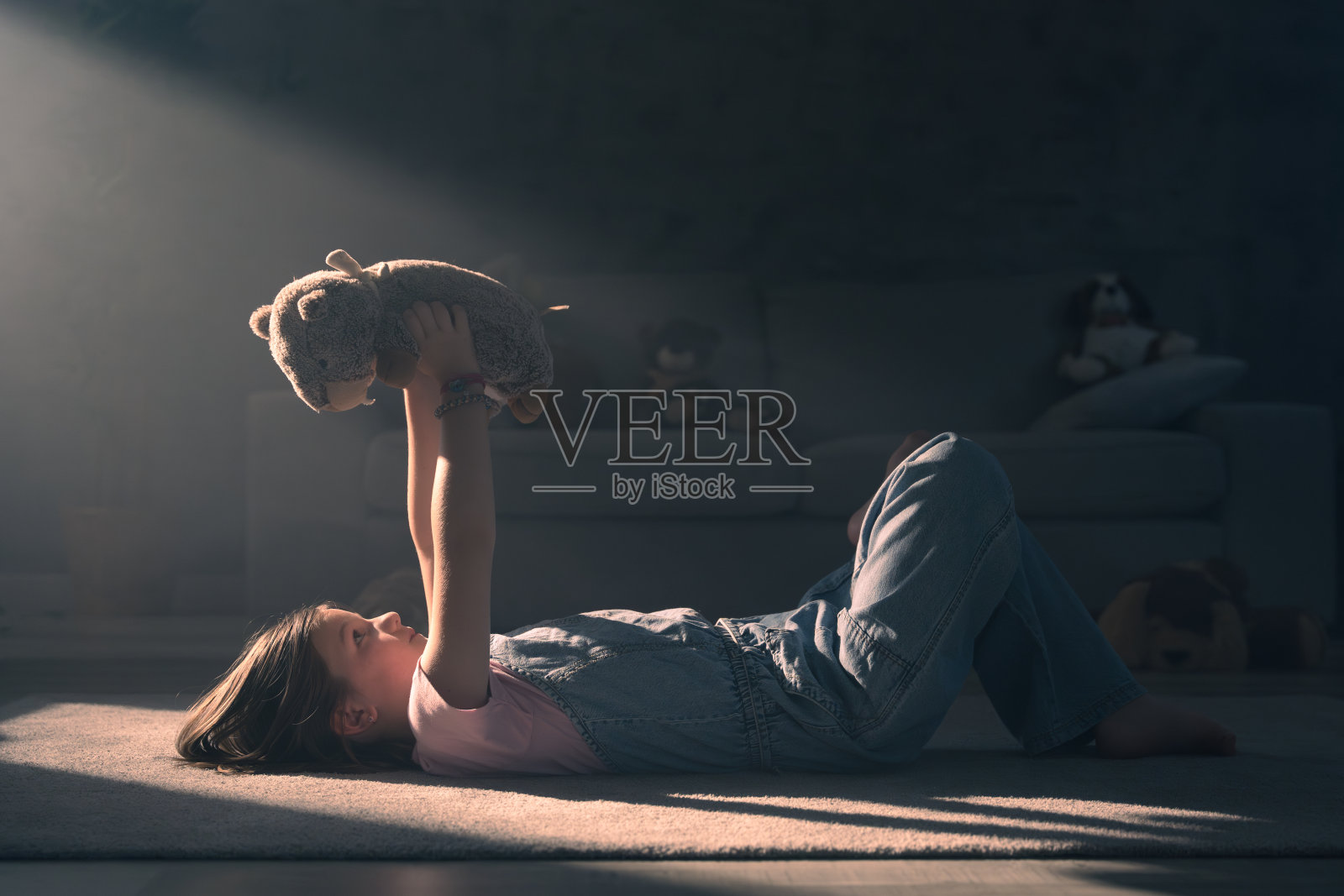 孩子躺在地板上玩玩具照片摄影图片