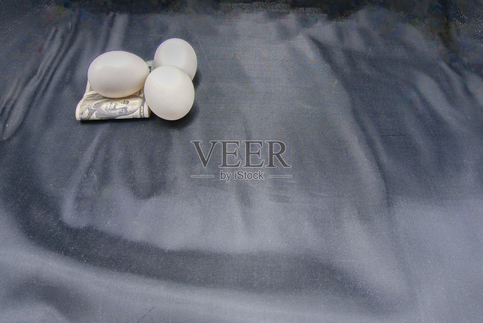 鸡蛋和钱的照片在黑色的背景。照片摄影图片